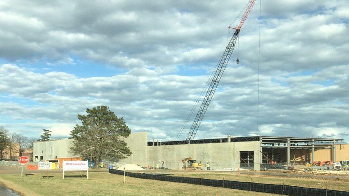 Crane setting a tilt-up concrete panel against a steel-framed commercial building