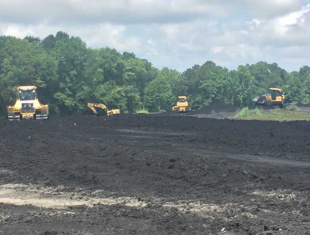 Fleet of trucks staged for an ash pond closure project