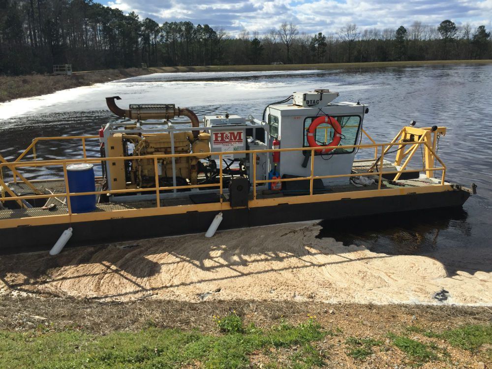 Dredge boat with pump working a body of water