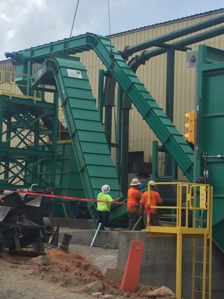 Crew installing a fuel conveyor system at an industrial facility